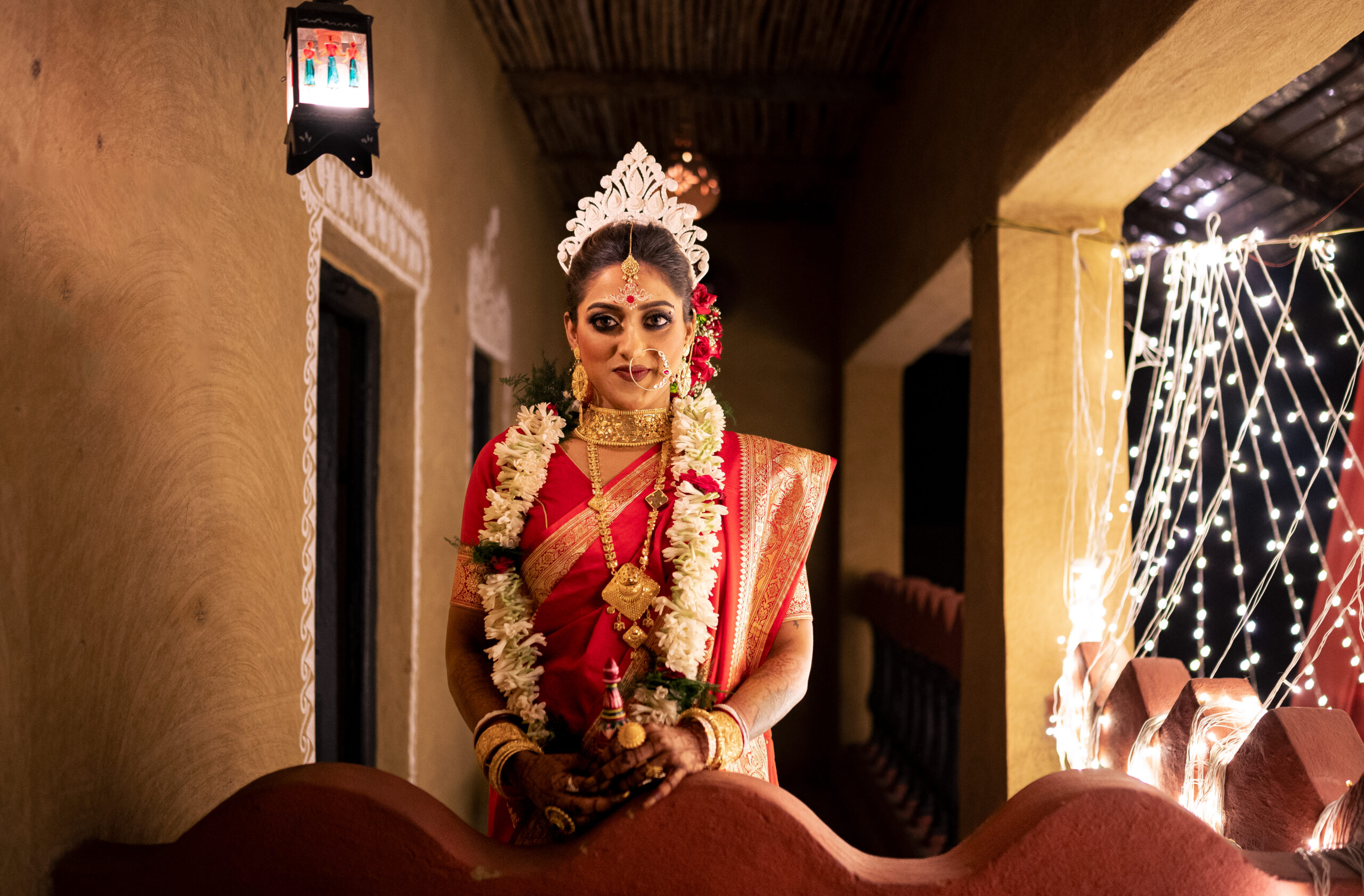 bride in kolkata standing next to fairy light in wedding